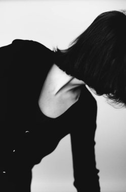 Siyah elbiseli esmer kızın şık ve minimalist portresi. Grim stüdyo kadın portresi