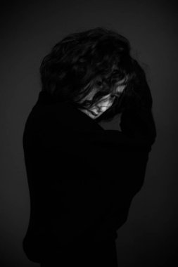 Siyah elbiseli bir kadının dramatik portresi.