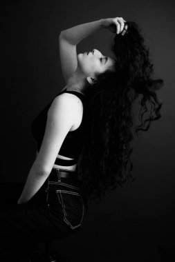A sensual black and white portrait of a brunette girl with curly hair.