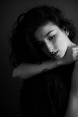 A sensual black and white portrait of a brunette girl with curly hair.