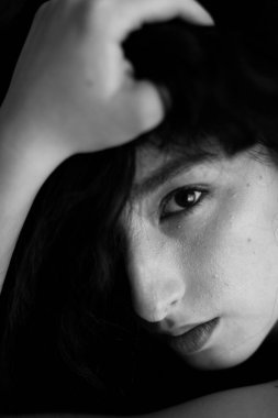 A sensual black and white portrait of a brunette girl with curly hair.