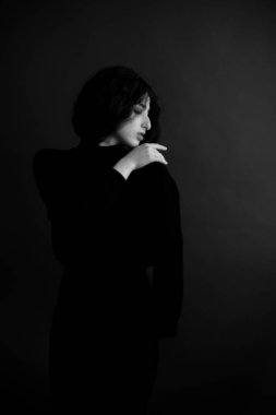 Stüdyoda bir esmerin moda portresi, el hareketleri, yüz ve avuçların duruşu.