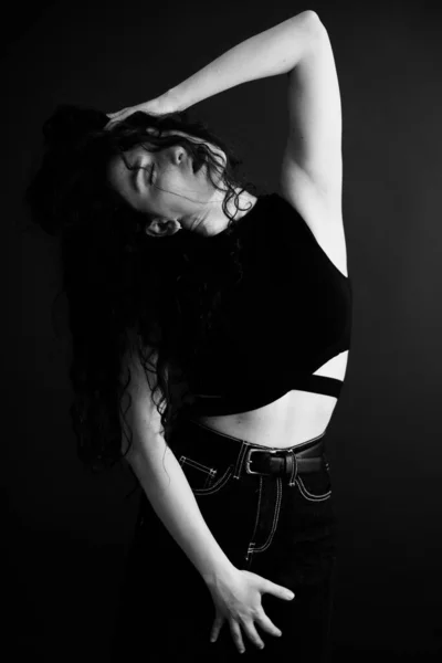 一个卷曲的黑发的简朴而时髦的肖像 相机的自由姿势 黑色软焦点 — 图库照片