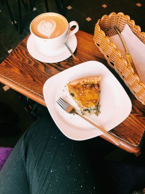 Cappuccino bardağı ve kiş, bir kahve dükkanındaki yiyeceğin soyut arka planı.