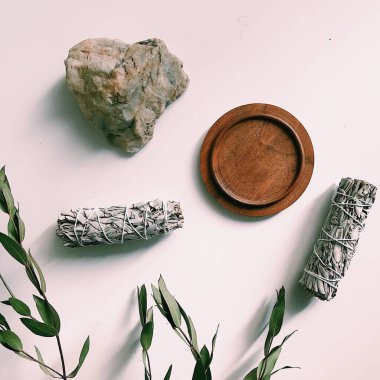 the layout of incense on a neutral background. palo santo and white sage, eucalyptus leaves and wooden stand