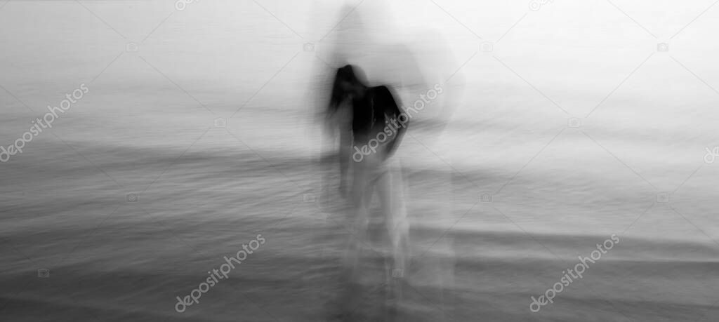 art photography, portrait by the sea, blurred silhouette of a woman and soft focus background