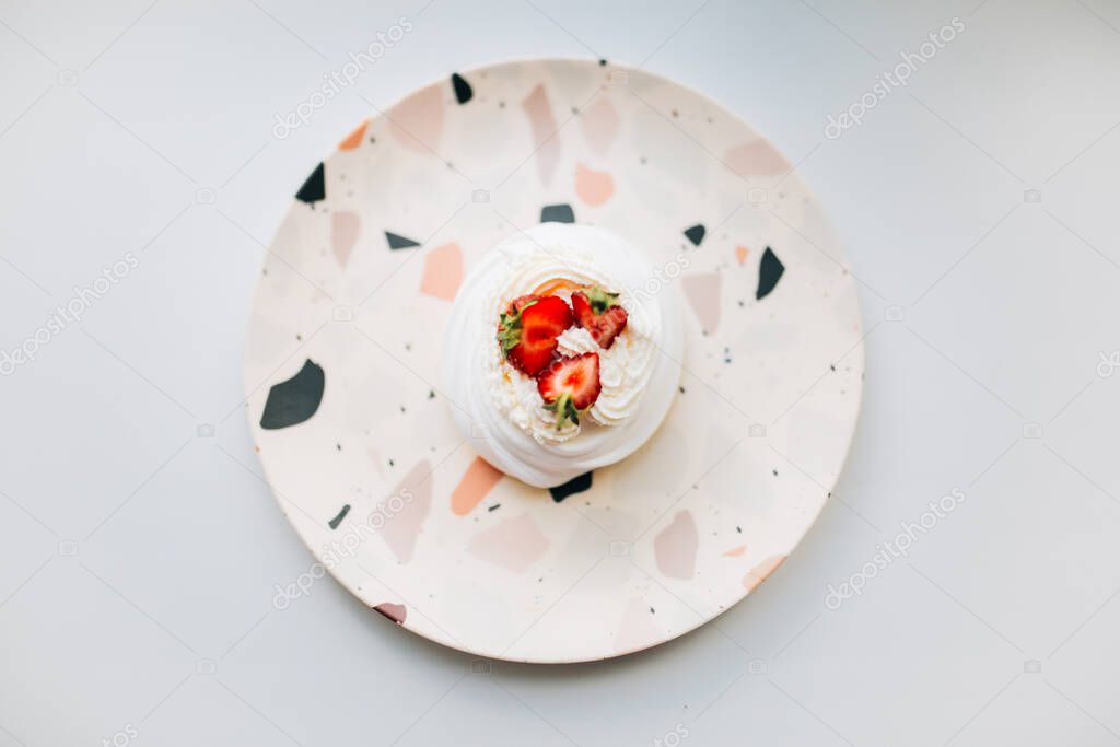 Pavlov's cake on a light background, a sweet dessert with custard and strawberries, in the top view, a place for text. 