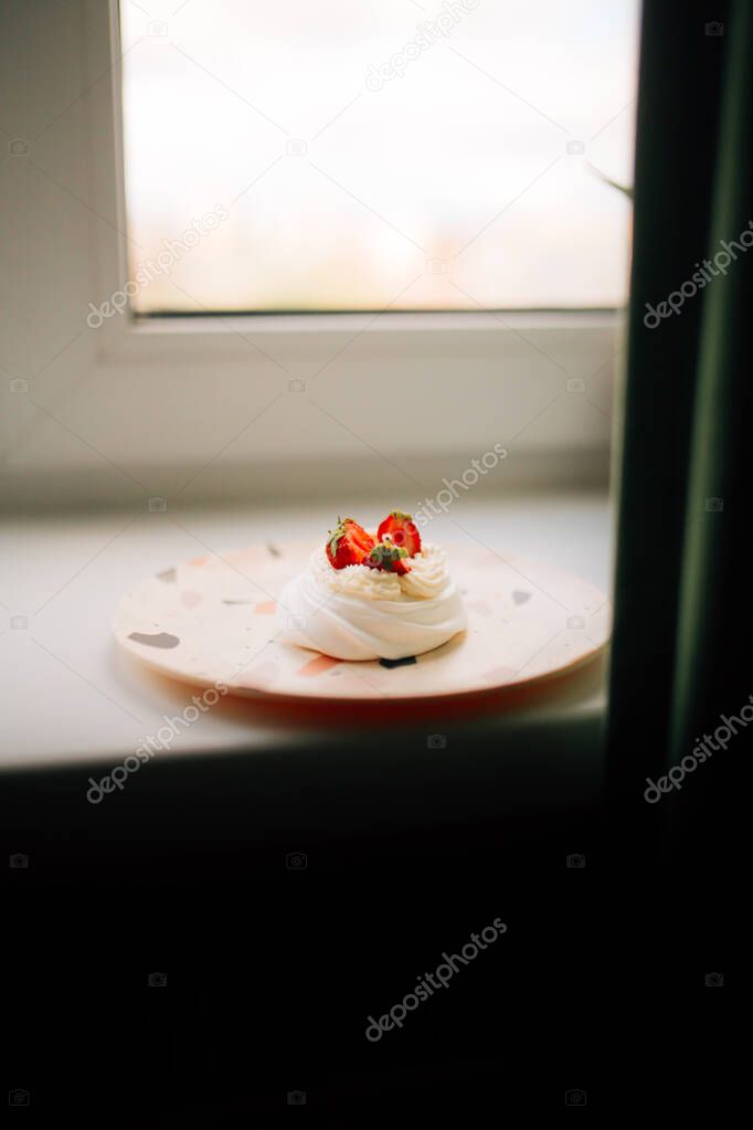 Sweet dessert, Pavlov's cake with butter cream and strawberries. Soft focus background, a place for text .