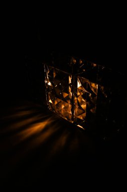 Siyah arkaplanda cam küp ve sarı aydınlatma, metin için boşluk