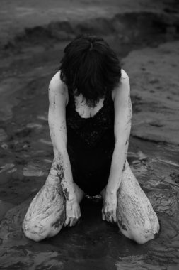 Bir dansçı plajda özgürce hareket eder, siyah beyaz filmdeki bir dansçının sanat çekimleri. Plajda siyah elbiseli bir kadın.