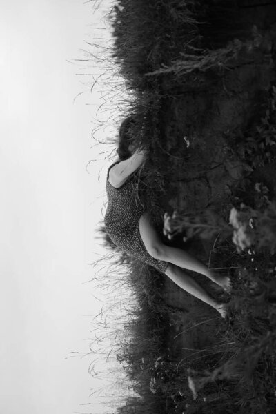 The girl is lying in the grass, embracing with plants. art black and white frame, a walk in nature