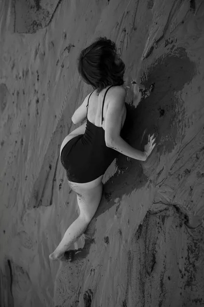 ビーチでダンサーが自由に動き黒と白のフィルムでダンサーの芸術撮影 ビーチで黒いボディスーツの女性が — ストック写真