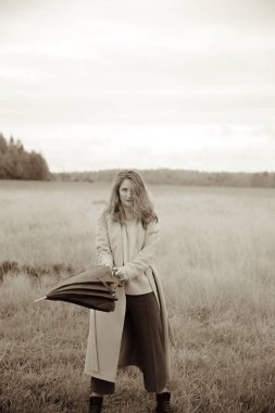 Sonbahar fotoğrafı, bir kız ve şemsiye, sonbahar tarlasında yürüyüş, siyah beyaz film bulanık fotoğraf.