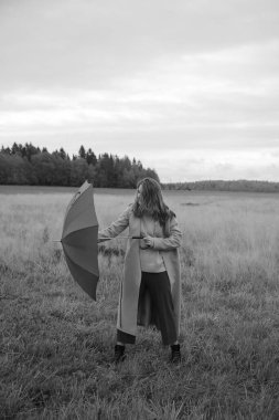 Sonbahar fotoğrafı, bir kız ve şemsiye, sonbahar tarlasında yürüyüş, siyah beyaz film bulanık fotoğraf.