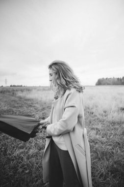 Sonbahar fotoğrafı, bir kız ve şemsiye, sonbahar tarlasında yürüyüş, siyah beyaz film bulanık fotoğraf.