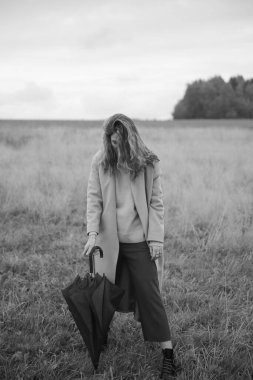 Sonbahar fotoğrafı, bir kız ve şemsiye, sonbahar tarlasında yürüyüş, siyah beyaz film bulanık fotoğraf.