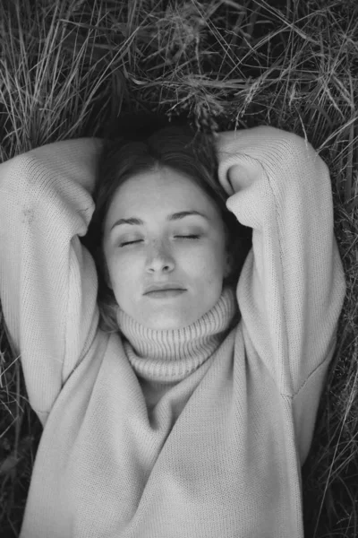 俄罗斯田野里的一个女孩躺在草地上 拍着黑色和白色的秋天照片 — 图库照片