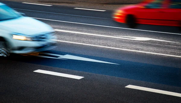 Coches que van a lo largo de la encrucijada al anochecer — Foto de Stock