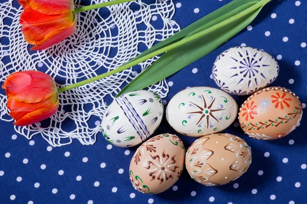 Ovos de Páscoa pintados na toalha de mesa azul — Fotografia de Stock
