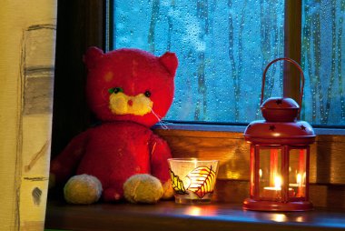 old plush tomcat is sitting by the window clipart