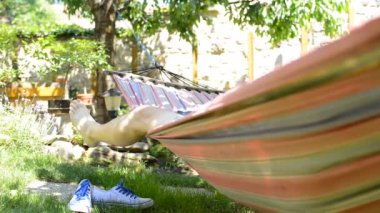 Bahçede bir hamakta yatan adam