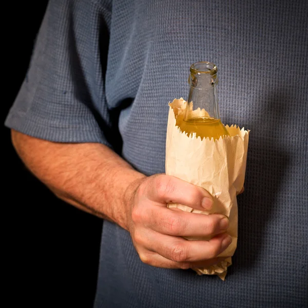 Drinker holds a bottle in the paper bag Stock Photo