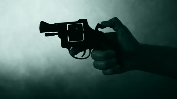 Silhouette di una mano di uomo con una pistola — Video Stock