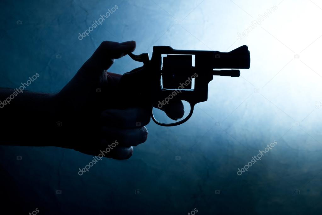 Silhouette of a mans hand with a handgun