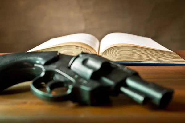 Open book with handgun — Stock Photo, Image