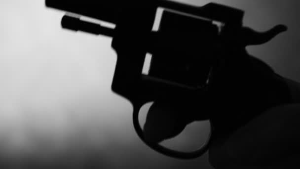 Silhouette di una mano di uomo con una pistola — Video Stock