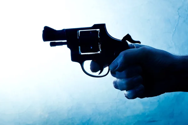 Silhouette of a mans hand with a handgun — Stock Photo, Image