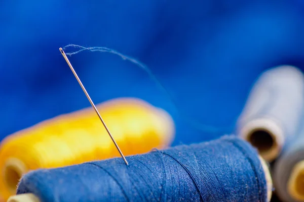 Nål och blå och gul tråd, kort skärpedjup — Stockfoto