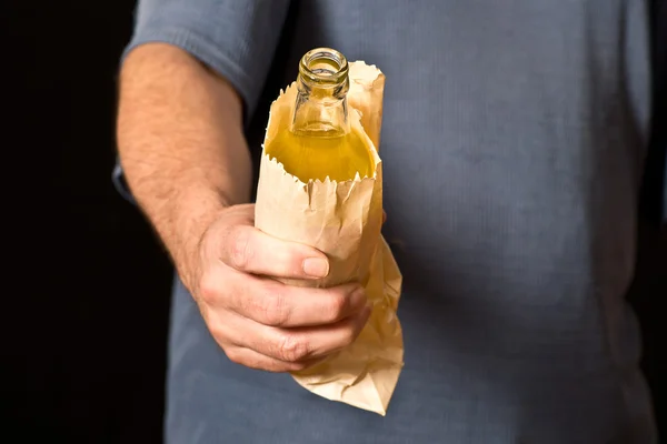 Drinker holds a bottle in the paper bag — Stock Photo, Image