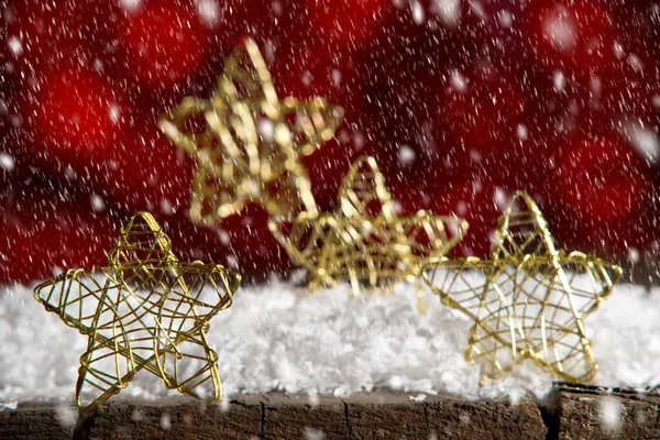 Goldene Weihnachtssterne auf rotem Hintergrund — Stockfoto