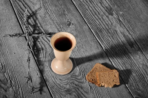 Чаша и хлеб на деревянном столе — стоковое фото
