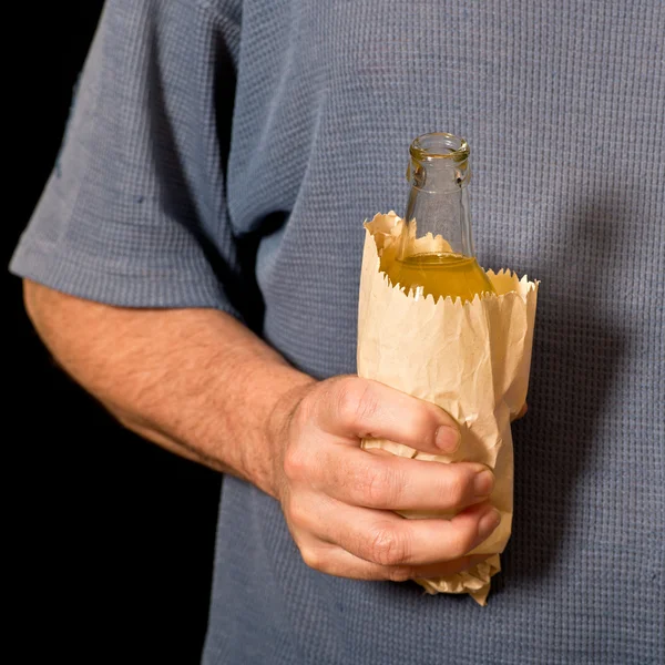 Drinker holds a bottle in the paper bag — Stock Photo, Image