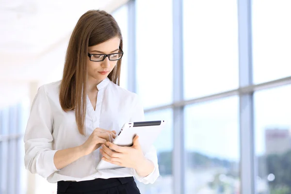 Modern affärskvinna skriva på bärbar dator när du står på kontoret innan mötet eller presentationen — Stockfoto