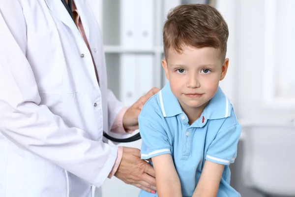 Dokter en patiënt in het ziekenhuis. Gelukkige kleine jongen die plezier heeft terwijl hij wordt onderzocht met stethoscoop. Gezondheids- en verzekeringsconcept — Stockfoto
