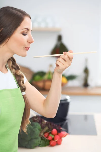 Jovem Cozinhando Numa Cozinha Dona Casa Degustação Sopa Por Colher — Fotografia de Stock