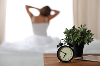 Kadın uyandıktan sonra yatakta geriniyor, geriye bakıyor, iyi bir uykudan sonra bir güne mutlu ve rahat giriyor. Tatlı rüyalar, günaydın, yeni gün, hafta sonu, tatil konsepti.