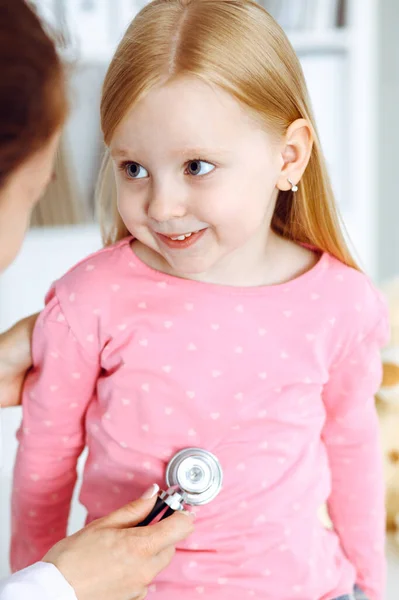 Feliz sorriso feminino criança-paciente na inspeção médica habitual. Médico e jovem na clínica. Medicina, conceitos de saúde — Fotografia de Stock