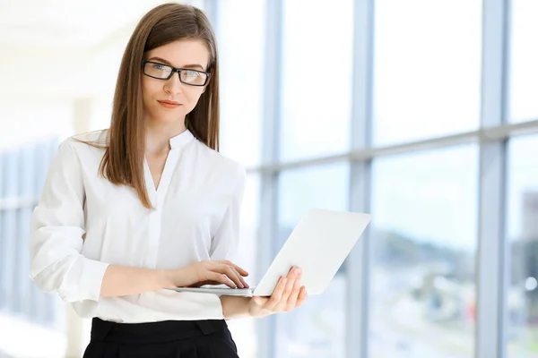 Hermosa Especialista Femenina Con Ordenador Portátil Pie Oficina Moderna Sonriendo — Foto de Stock