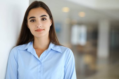 Dost canlısı genç bir iş kadını ya da bayan öğrenci ofiste bazı evraklarla duruyor. Yaşam tarzı ve çeşitli insanlar konsepti.