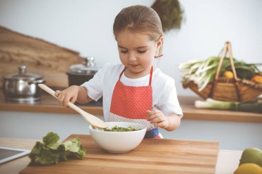 Mutlu kadın ve kızı aile ziyafeti için sağlıklı vejetaryen salatası ve atıştırmalıklar yapıyorlar. Noel, yeni yıl, Şükran Günü, yıldönümü, anneler günü. Sağlıklı yemek pişirme kavramı.