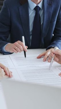 Ofisteki beyaz masada bir sözleşme imzalayan işadamı, iş arkadaşları müzakerelerin başarısını alkışlıyorlar. İş adamları konsepti.