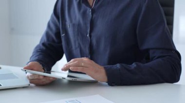 Businessman working with digital tablet and laptop computer at office desk, analyzing financial data and reports, developing business plan and strategy. Business people.