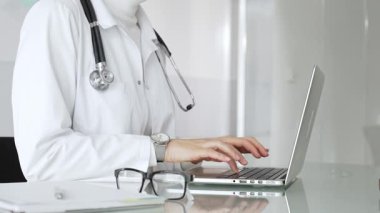 Profesyonel kadın doktor online danışmanlık yapıyor ya da sağlık kliniğindeki bilgisayarla hasta kayıtlarını belgeliyor. Tıp, sağlık ve bilim konsepti
