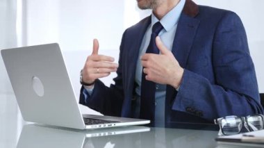 Sanal iletişim ve uzaktan çalışma için bir dizüstü bilgisayar kullanarak çevrimiçi bir toplantıya aktif olarak katılan bir iş adamı. İş adamları konsepti