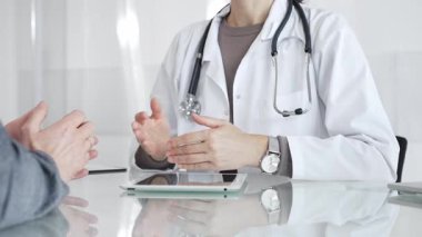 Doktor, klinik muayenesi, profesyonel bakım tartışması sırasında tıbbi verileri incelemek için tablet kullanan hastaya tedavi seçeneklerini açıklıyor. İlaç ve sağlık hizmetleri