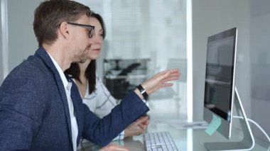 İş arkadaşları bilgisayar ekranında gösterilen finansal grafik ve grafikleri analiz ederek strateji ve piyasa performansını tartışıyor. İş insanları kavramı